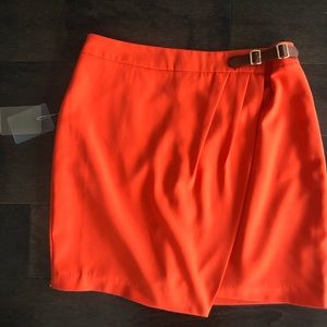 Bright orange draped skirt with brown belt